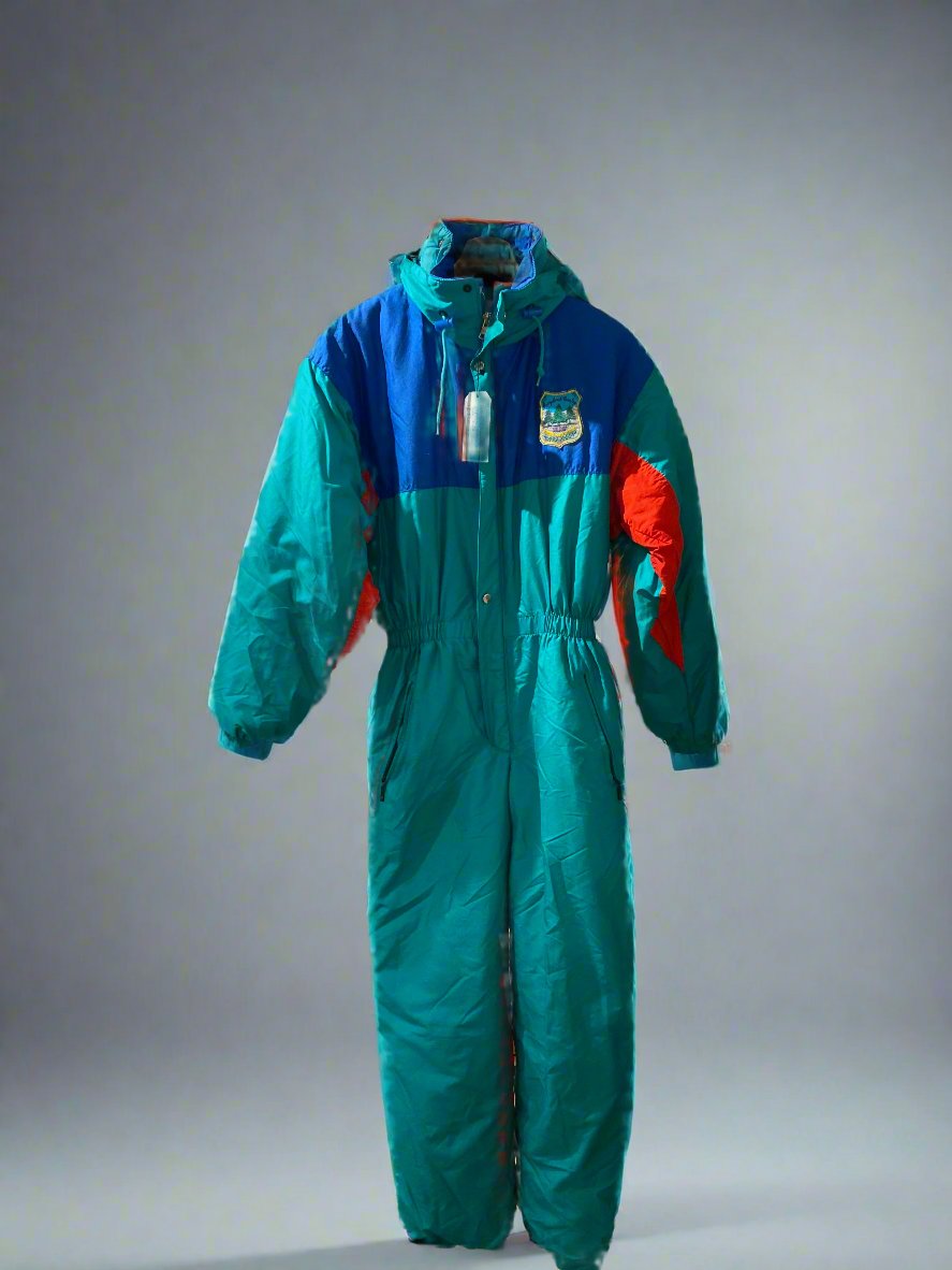 Vintage SKISS green, blue and red one-piece snow suit with an embroidered fabric patch on the left hand side of the chest, a fold away into the collar hood, and pockets on either side of the hips. Front