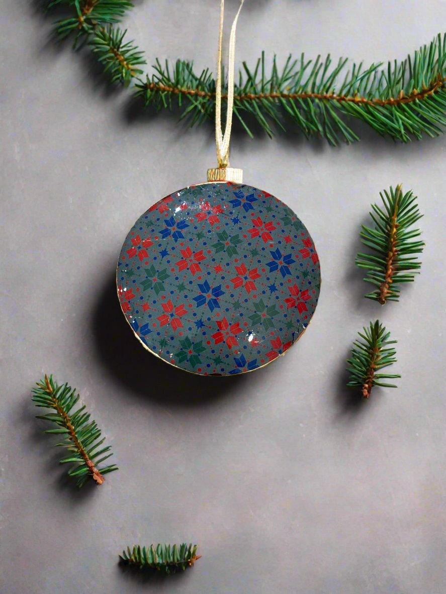 Back of disc, with red, blue and green pattern of snowflakes on a grey-green background