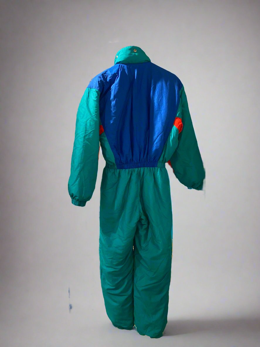 Vintage SKISS green, blue and red one-piece snow suit with an embroidered fabric patch on the left hand side of the chest, a fold away into the collar hood, and pockets on either side of the hips. Rear, showing hood folded away into the collar