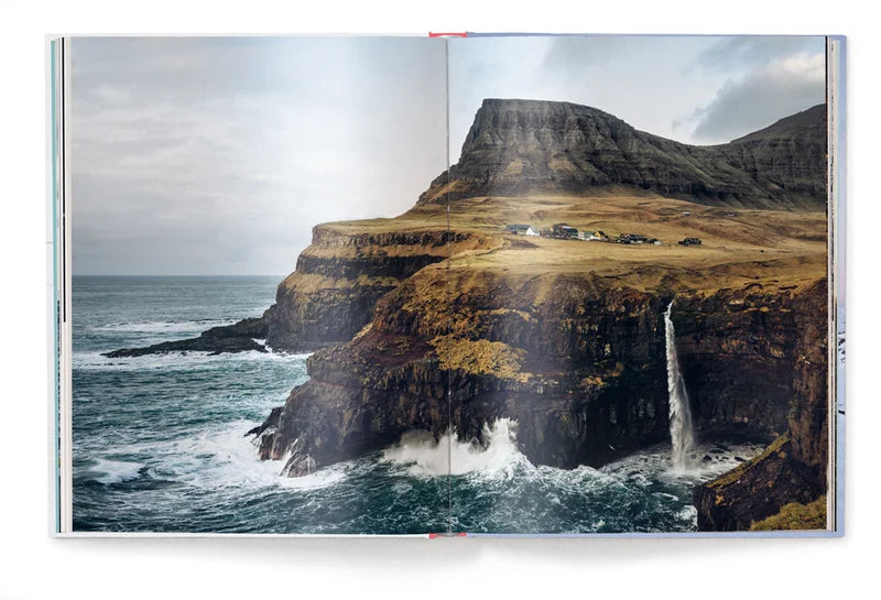 Image shows a page of the book, a photograph of a village on a rocky mountainous landscape giving way to rock cliffs leading straight into a choppy sea