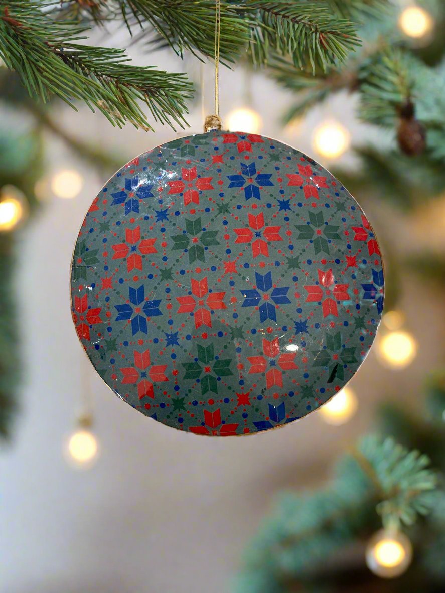 Back of disc, with red, blue and green pattern of snowflakes on a grey-green background