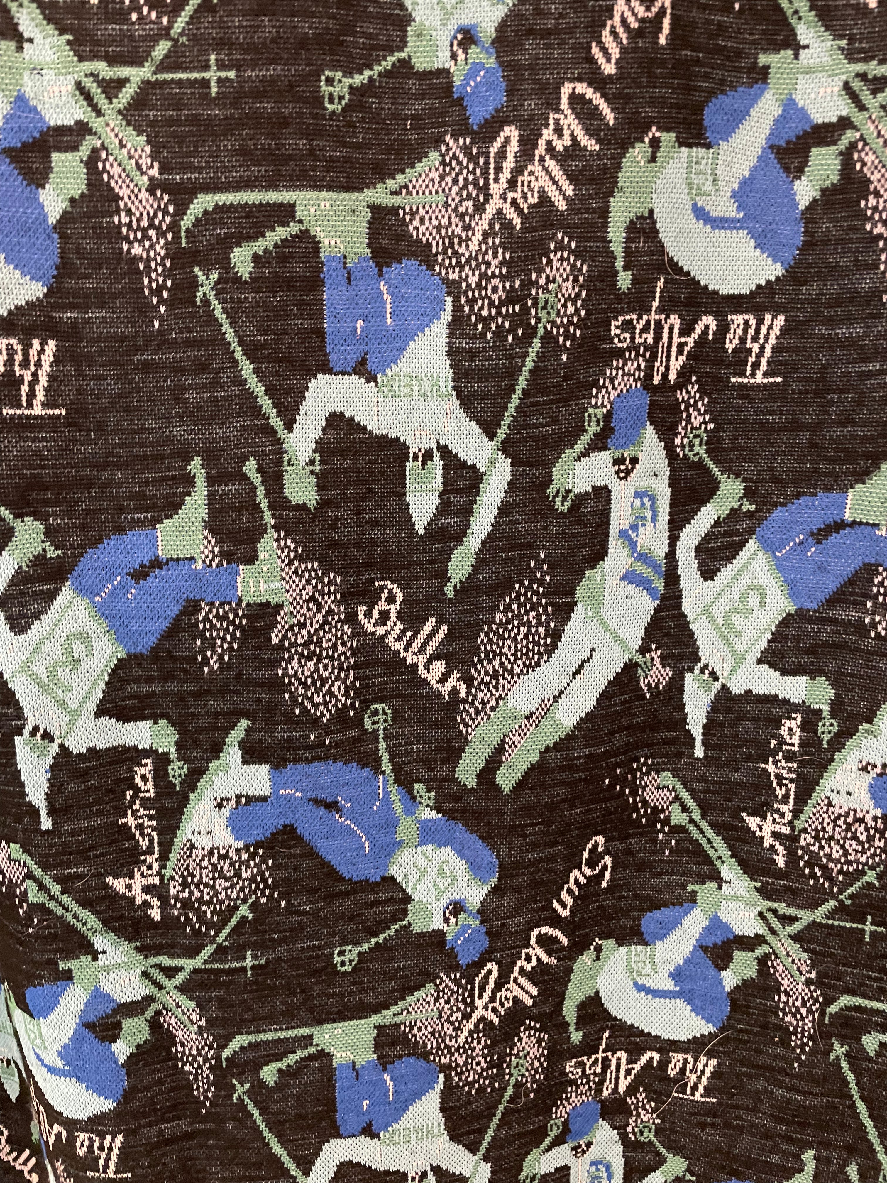"Mt Buller" A-line full length skirt with side zip. Size 14 (more like modern day 8-10). Pattern is teal and blue skiers on a black background with the words Buller, Sun Valley, The Alps, Austria printed in white. Close up of pattern