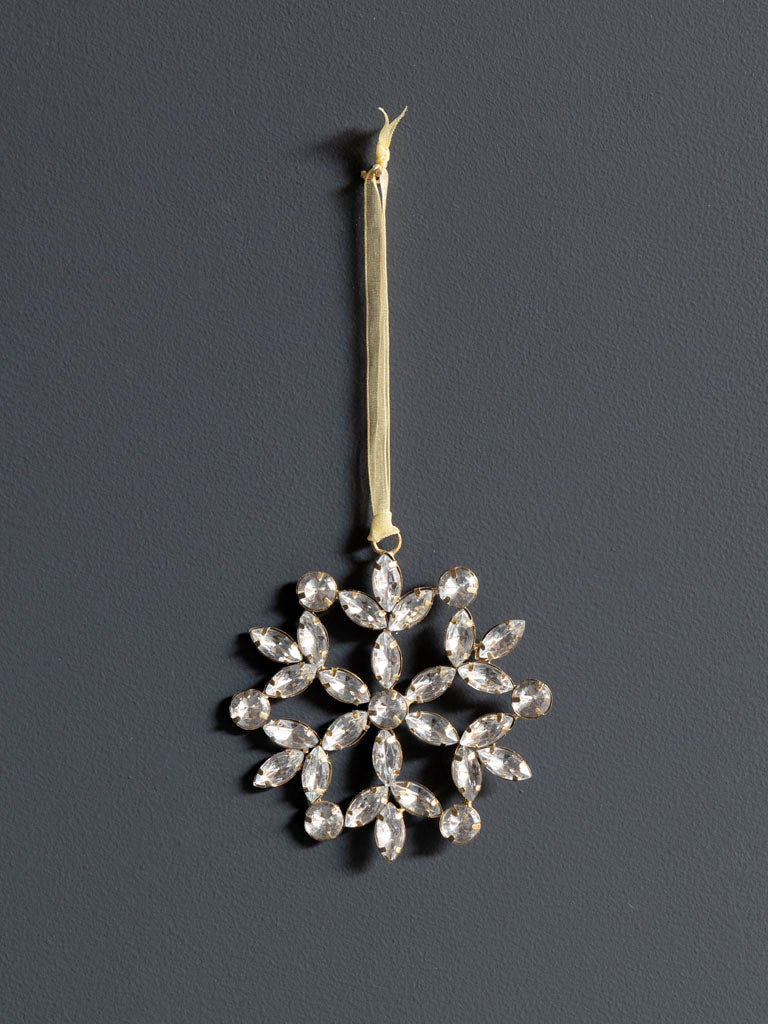 Hanging flowery silver snowflake against dark background