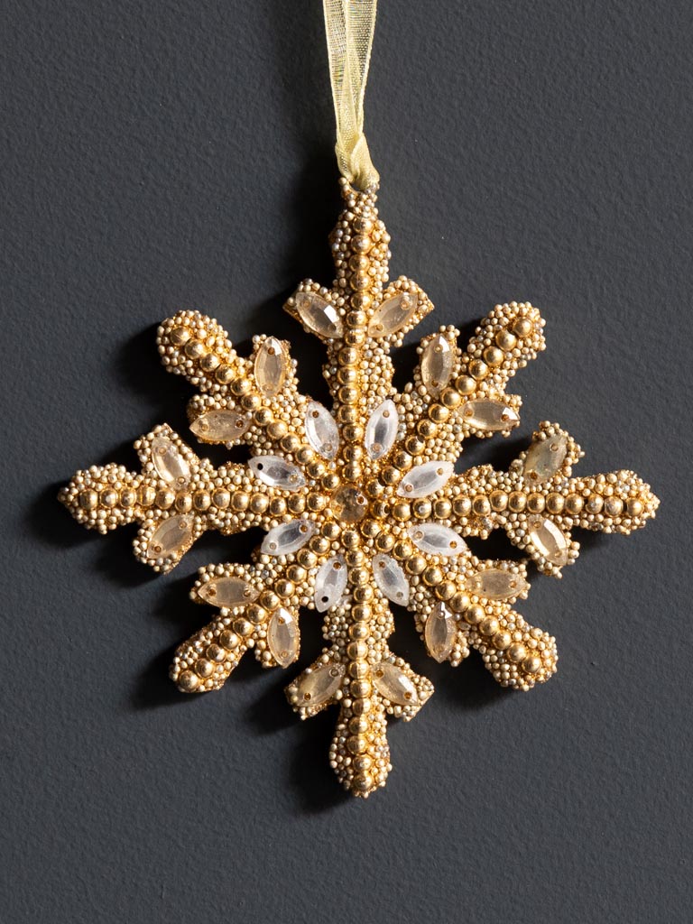 Golden Bead Snowflake, against dark background. Close up