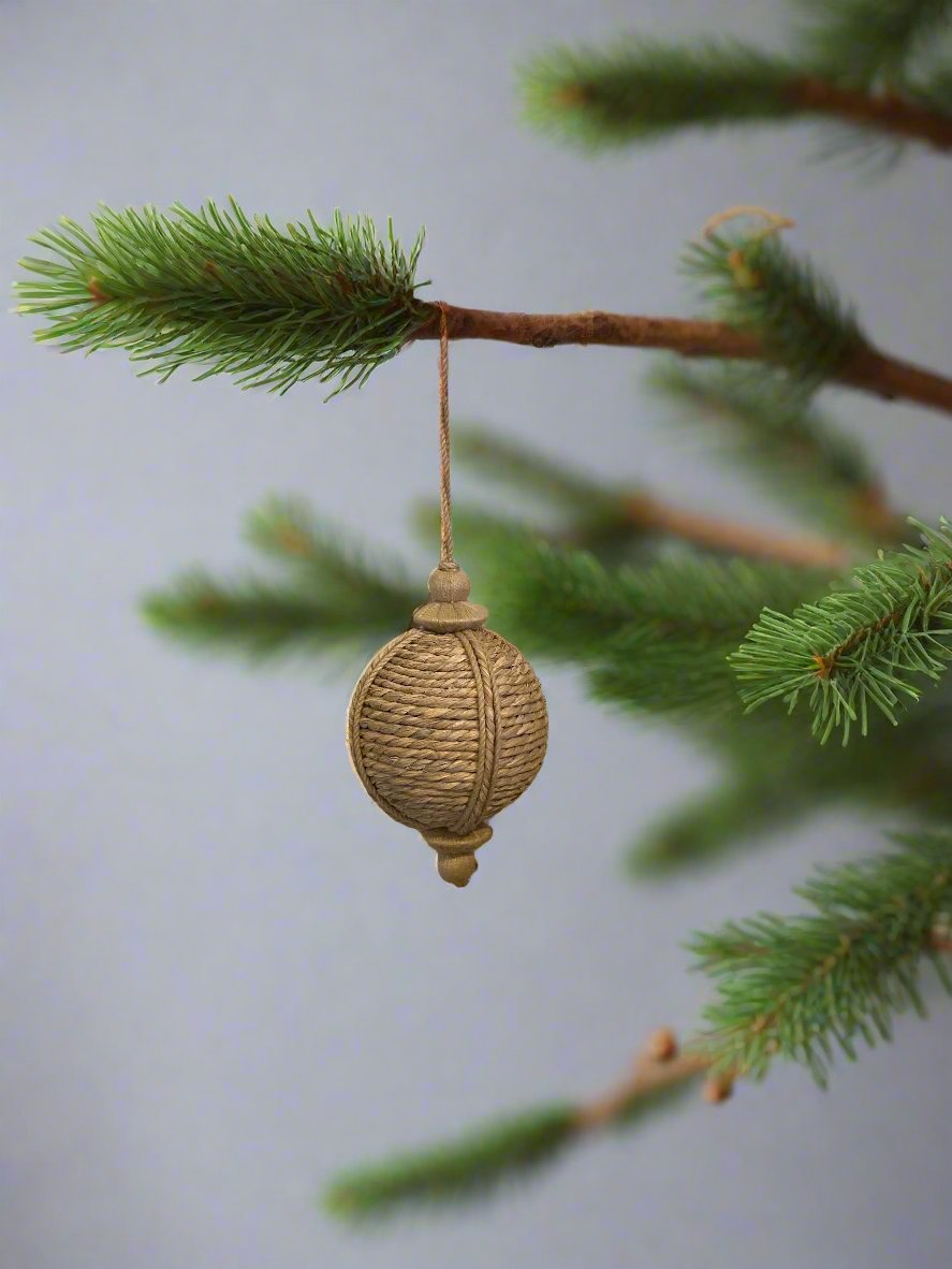 Round jute bouy shaped hanging ornament, shown hanging on a branch