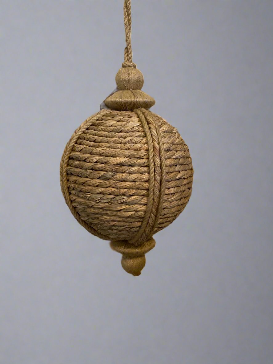 Round jute bouy shaped hanging ornament, shown hanging.