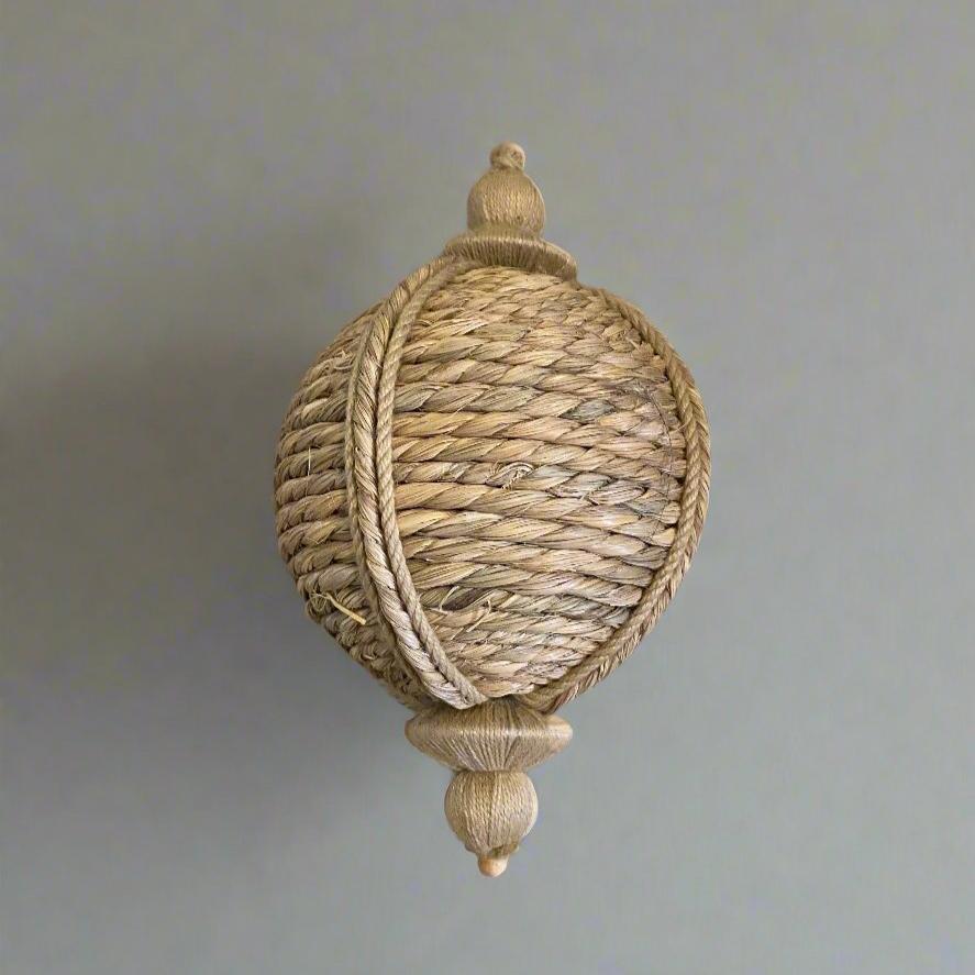 Round jute bouy shaped hanging ornament, displayed on a table.