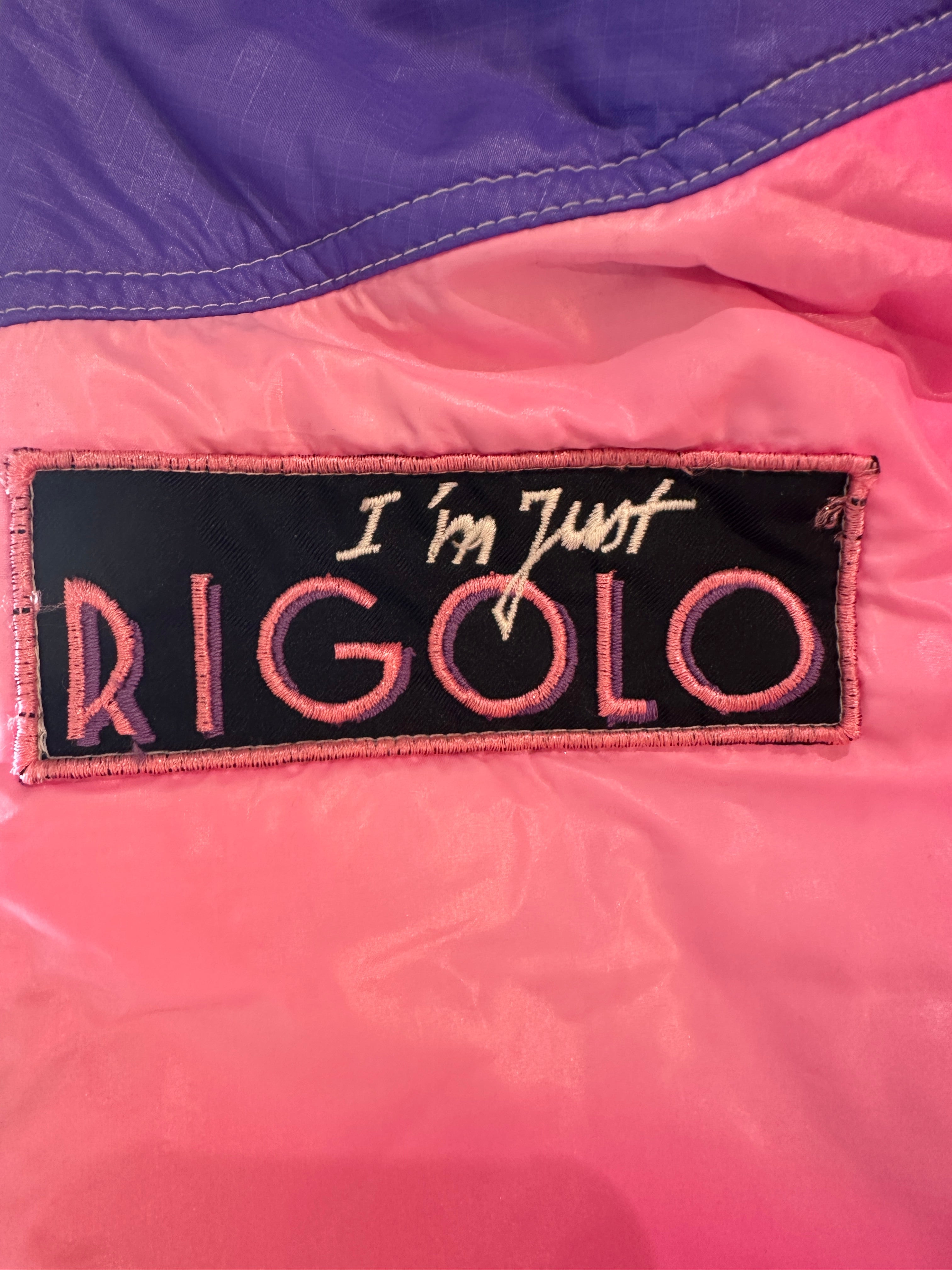 Patch on a suit with text 'I'm Just Rigolo' on a pink and purple background