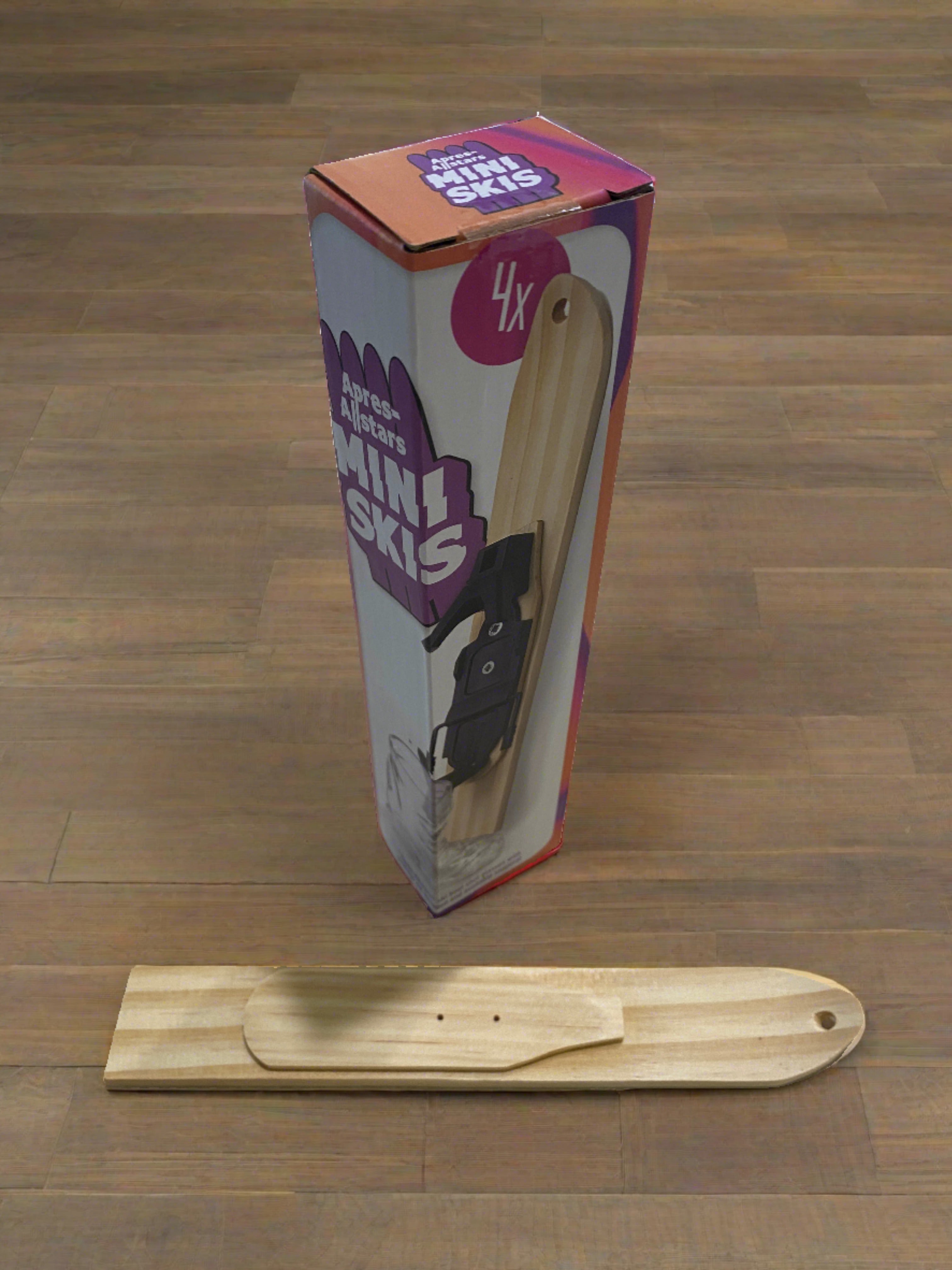 Photo of a wooden tray in the shape of small ski & the box it comes in. The ski tray has a hole drilled into the tip of the ski and a small raised mounting platform for the Apres Allstar boot shot glass and bindings. Image is set against a wooden backdrop