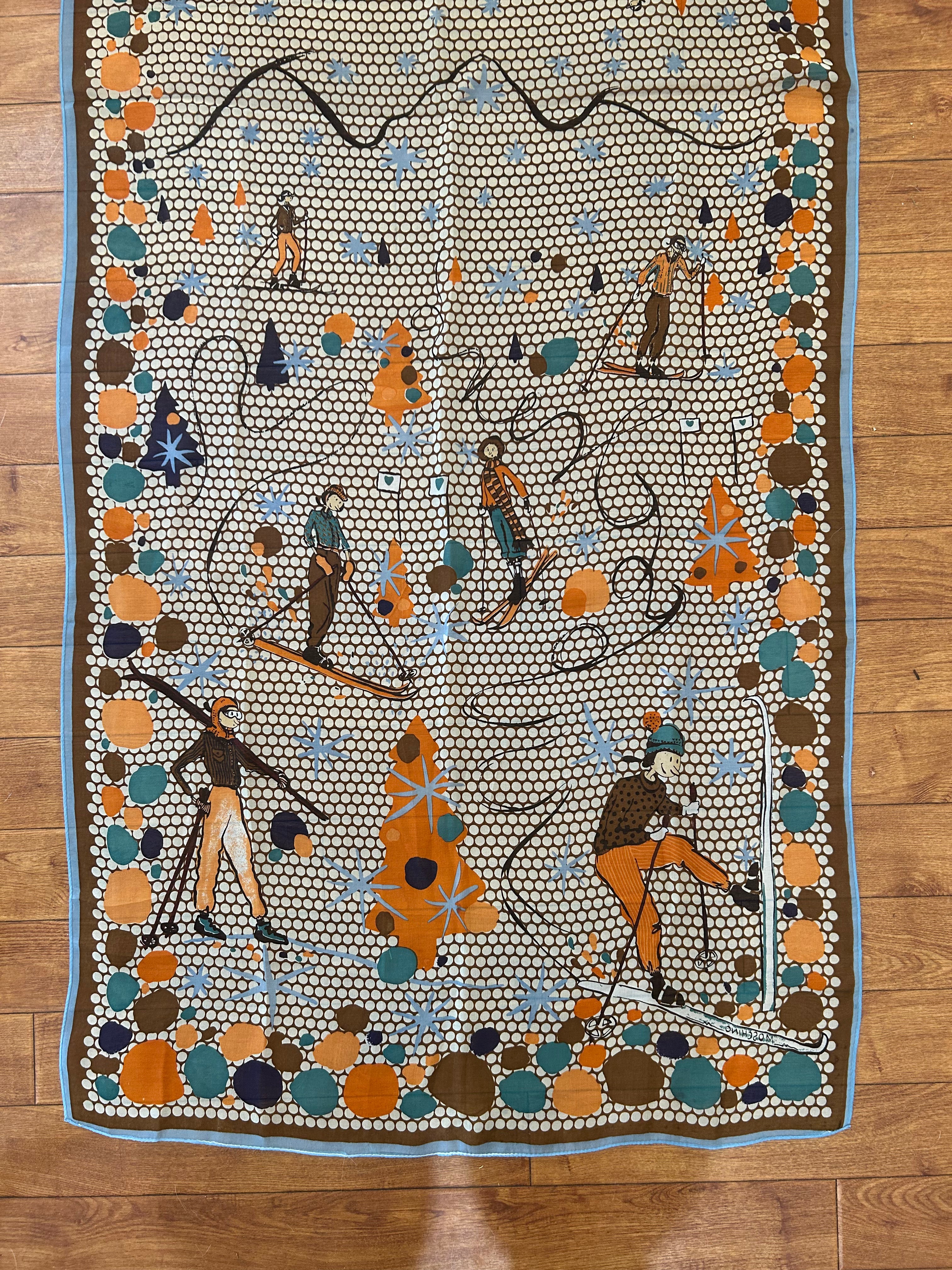 MOSCHINO brown, orange, teal blue silk scarf, patterned with people skiing and white polka dots.