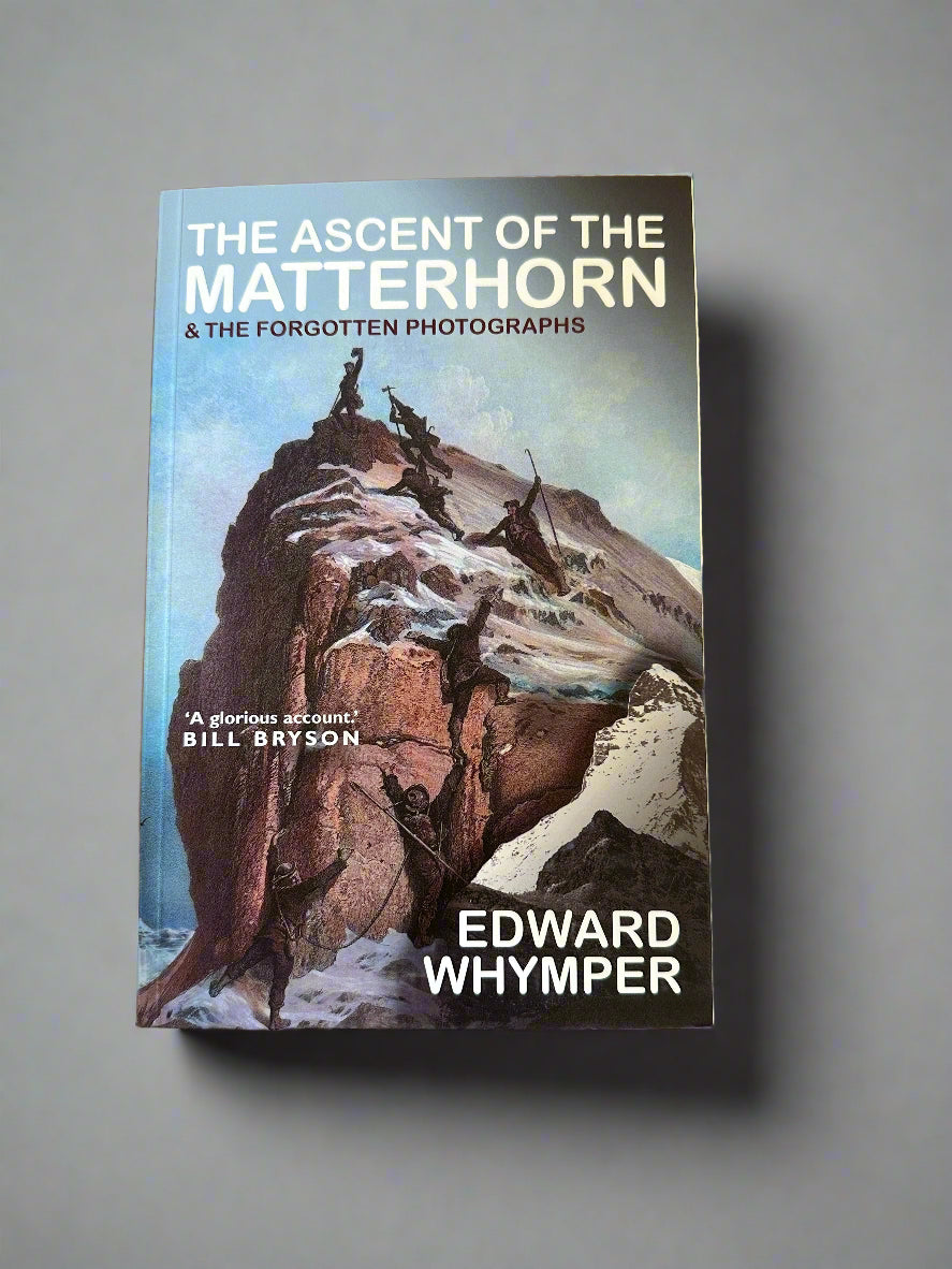 Front cover of the book The Ascent of the Matterhorn. Blue background with  a rocky snow capped mountain rising in the air and seven people with climbing gear ascending the rock. Book shown against a grey backdrop.