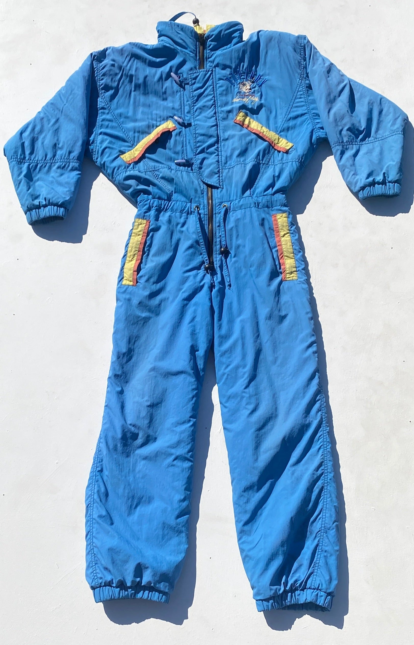 Vintage cornflower blue, with yellow and orange stripe "10S Pour 2" 1-piece snow suit with embroidery "Popcorn 10s Pour 2, A New World of Fantasy" on back shoulder and front right hand chest. Front flat lay