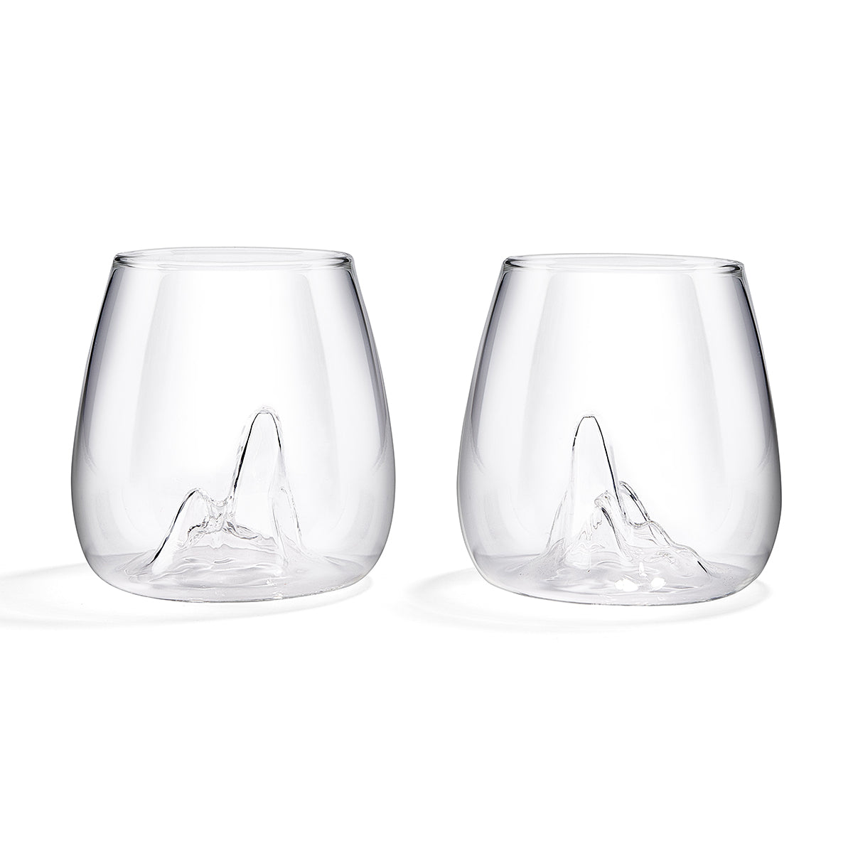 Image of a glass carafe with the shape of a mountain peak indented into its base. Set against a white background.