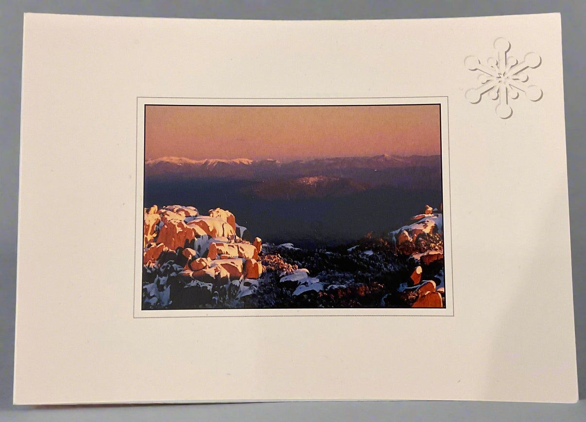 Sunset over snow covered boulders. Australian Alps Colour Post Card. White Border