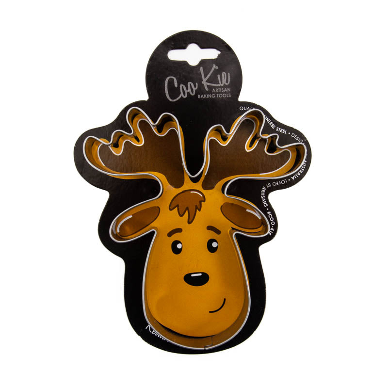 Image of a reindeer cookie cutter on a black cardboard depicting a reindeer’s face. Shown against a white backdrop. 