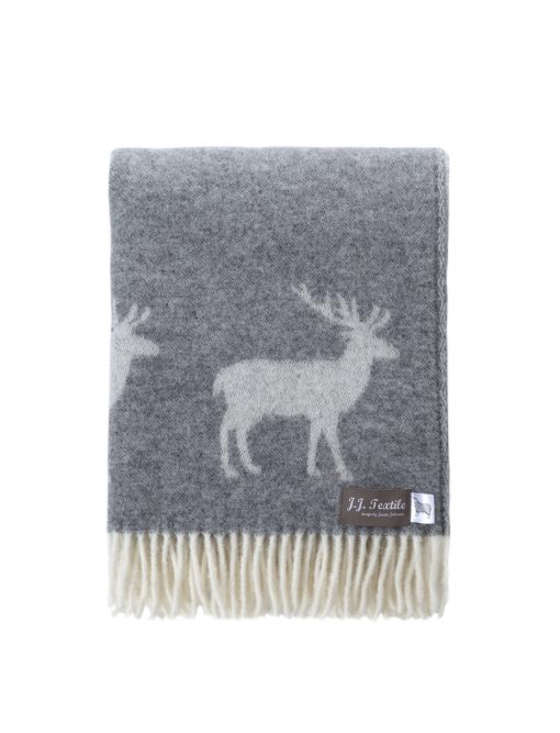 A throw rug, in a neutral soft grey with off-white deer design and made from 100% wool. Shown folded into sixths with the deer pattern & fringing visible.