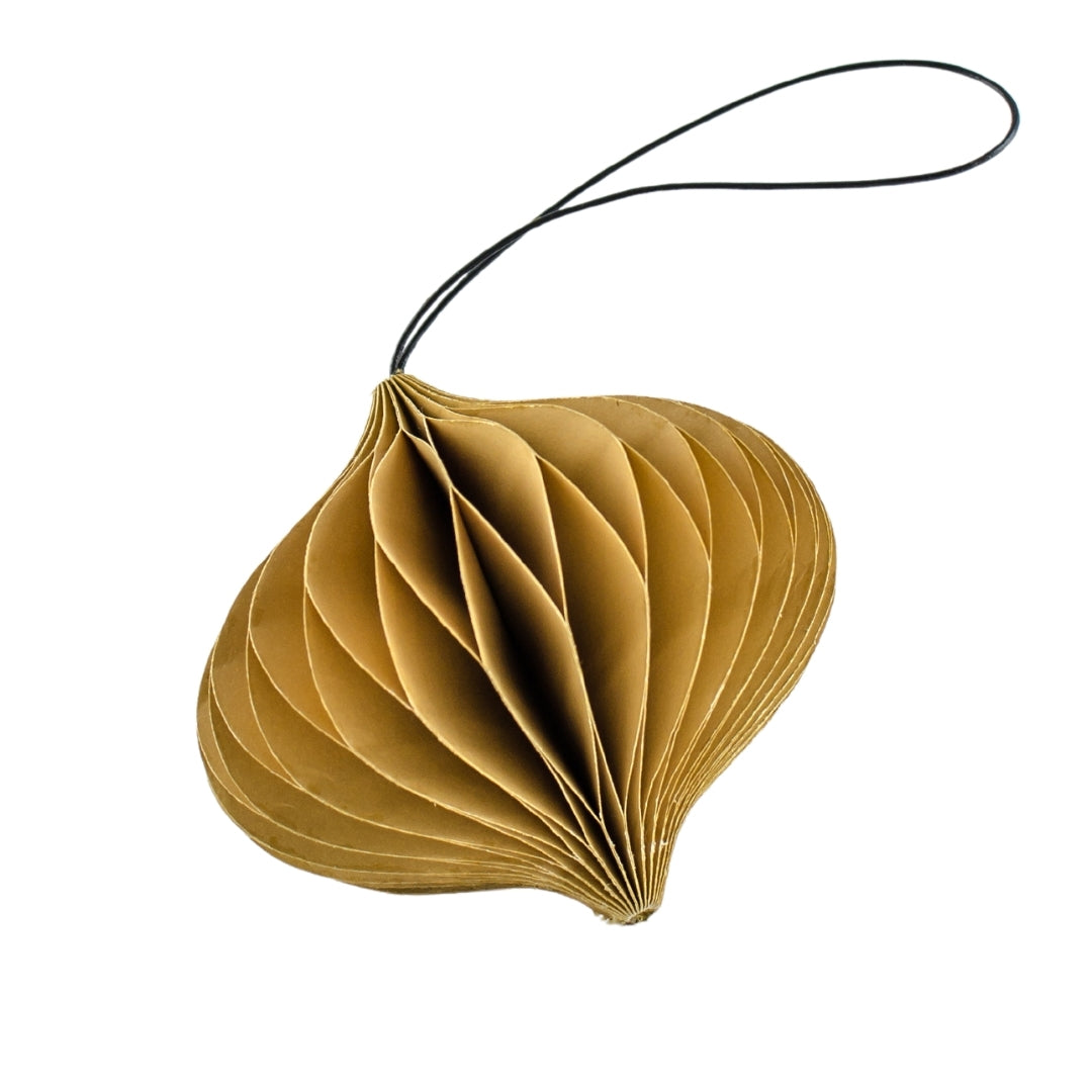 Golden sand coloured paper ornament in the shapes of a jewel against a while background