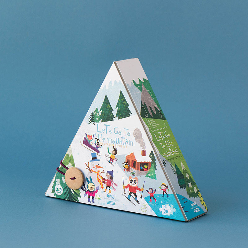 Image shows Triangular shaped puzzle box with images of people and animals enjoying winter snow activities on the front cover, against a blue background