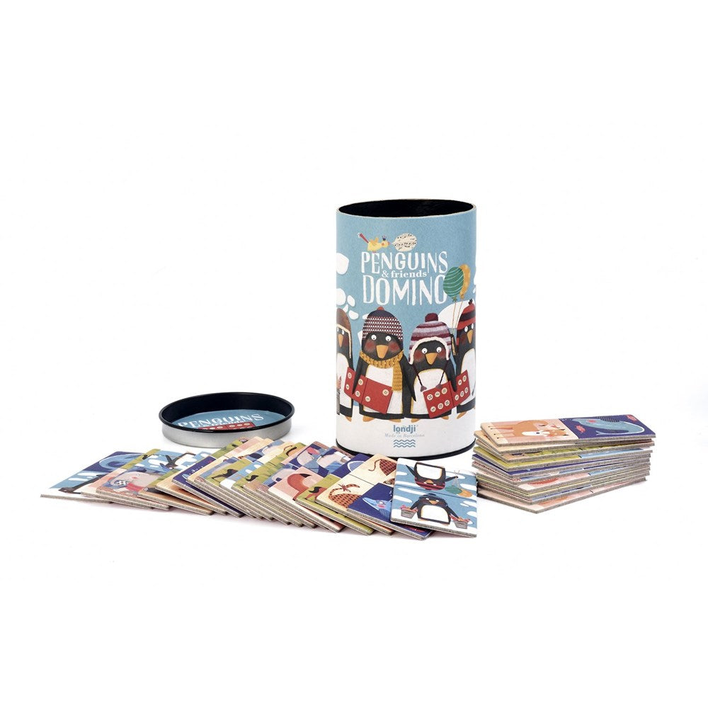 Images show a cylindrical open tin with a drawing of penguins and other animals dressed for the snow holding dominoes. Domino tiles are arranged in from of the tin, against a white background