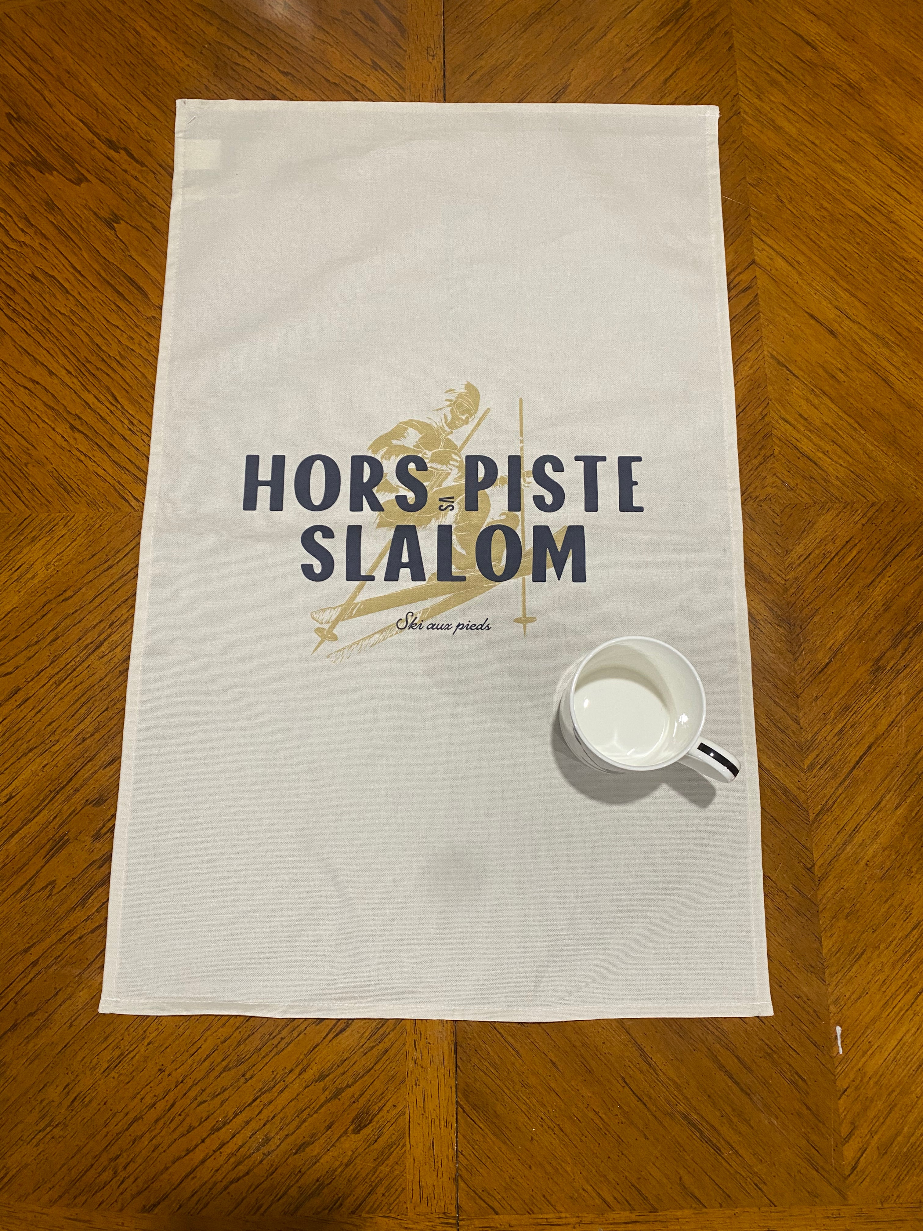 Hors Piste vs Slalom Tea Towel, Coast & Valley. shown with a mug for size