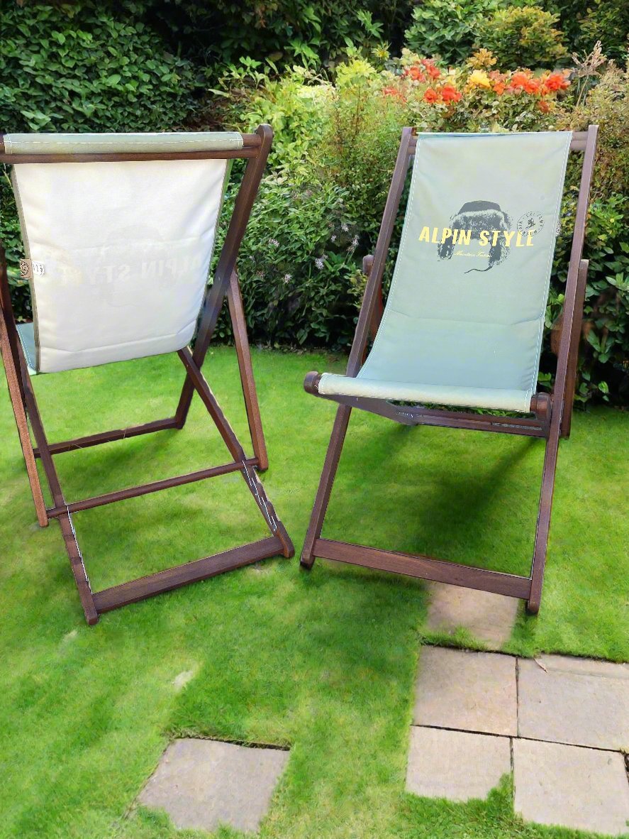 Pair of Coast & Valley Deck Chairs: Alpin Style design showing words in yellow with fur hat on a plain eucalyptus green background. 1 chair facing forward, the other facing backwards. 