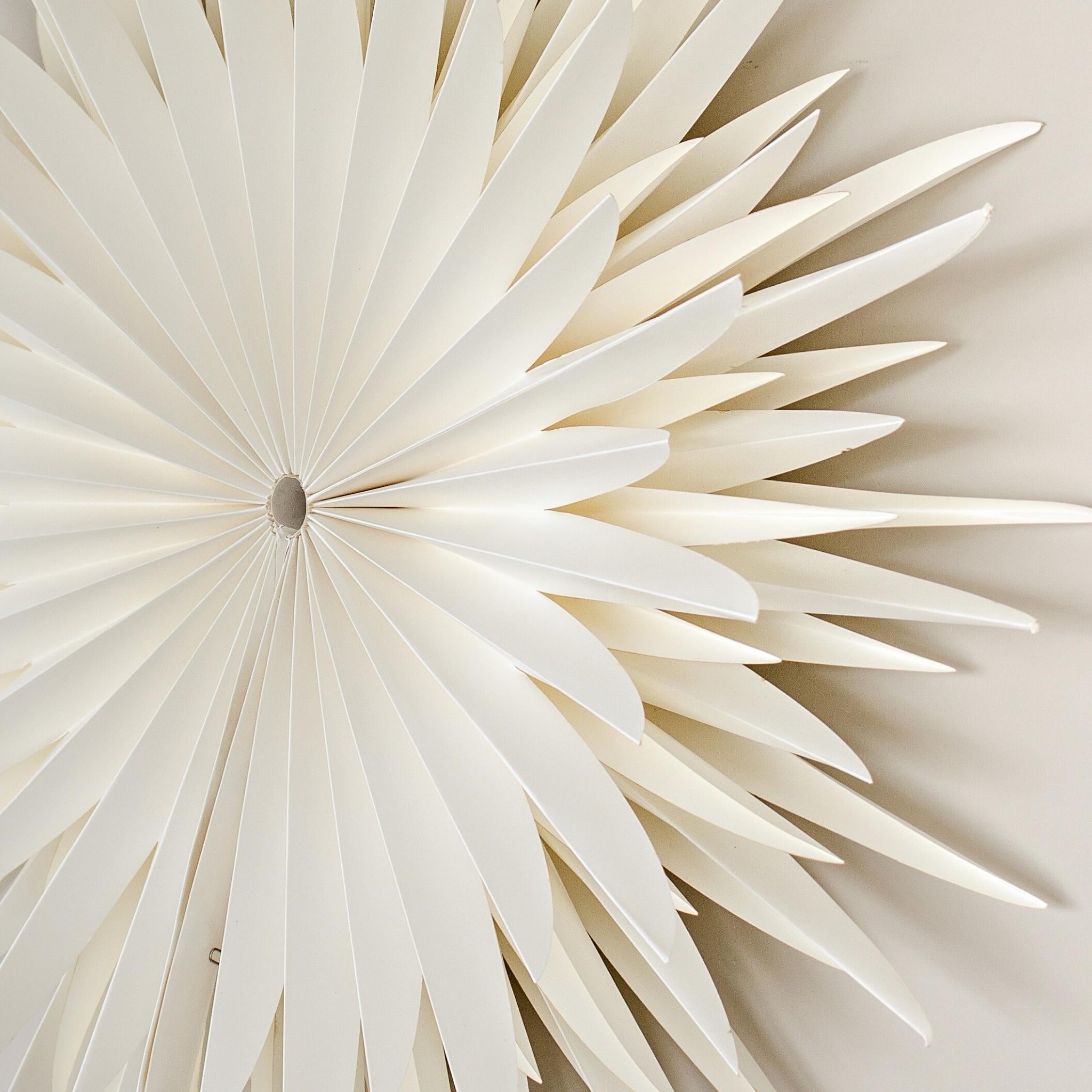 Close up side view of an Off-White Star Wall Hanging in 70cm diameter hanging on a beige wall