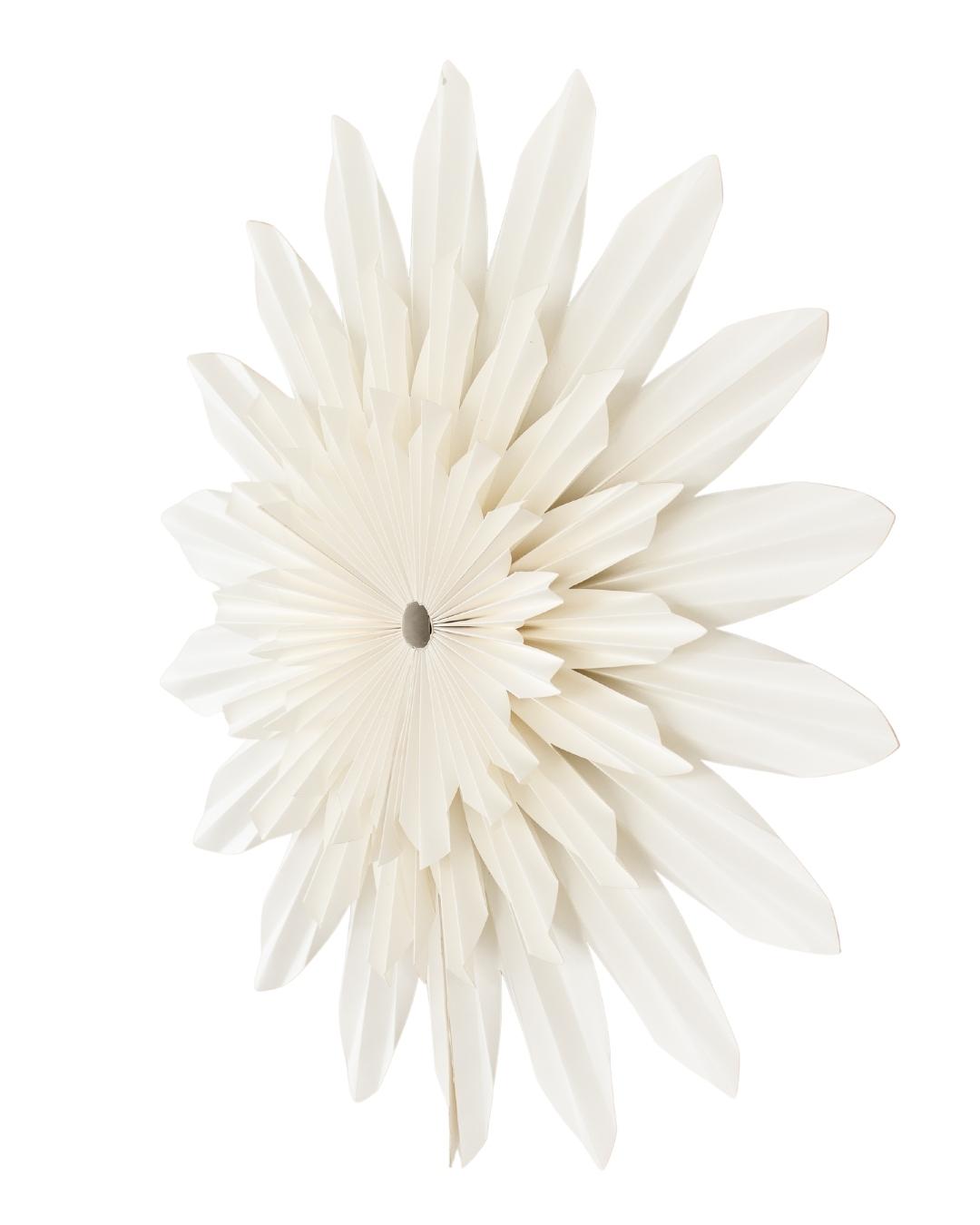 Off-white paper flower wall hanging against a white background viewed from an angle