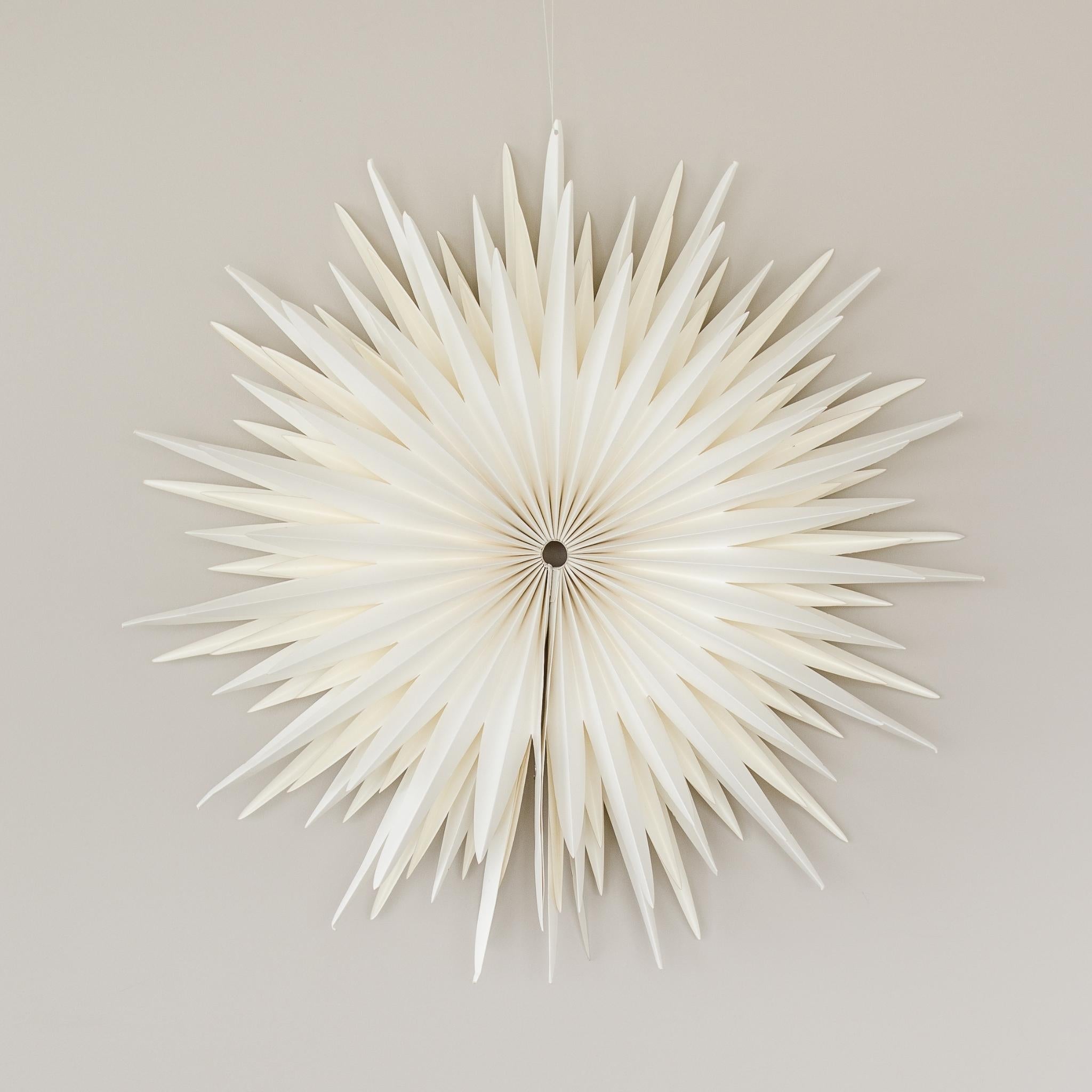 Off-White Star Wall Hanging in 70cm diameter hanging on a beige wall