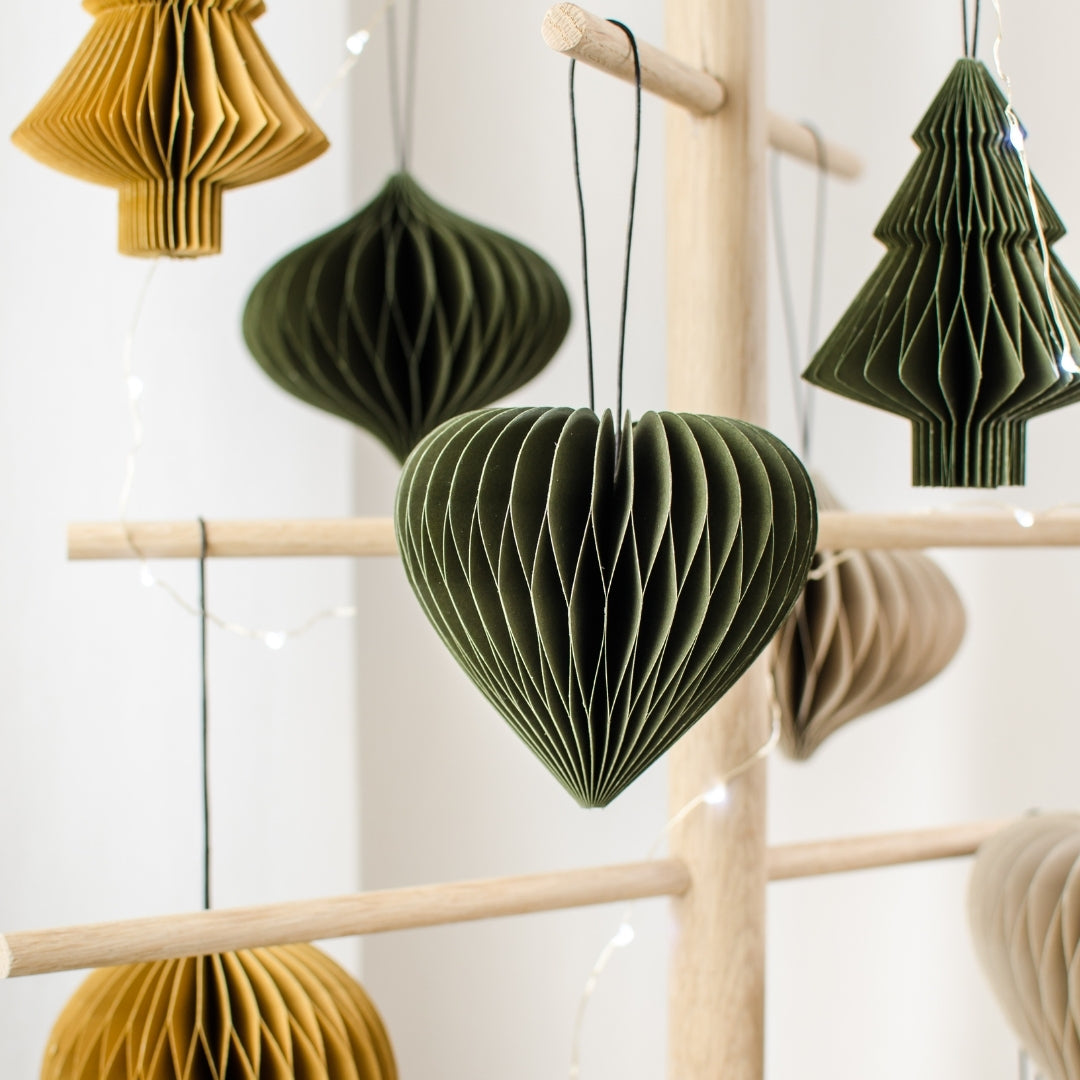 Variety of Olive Green, Rust and Linen Coloured Paper Christmas Ornaments hanging from a wooden tree frame, with an Olive Green heart ornament in the centre