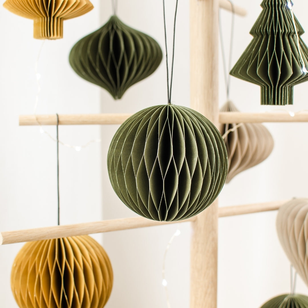 Variety of Olive Green, Rust and Linen Coloured Paper Christmas Ornaments hanging from a wooden tree frame, with an Olive Green sphere ornament in the centre