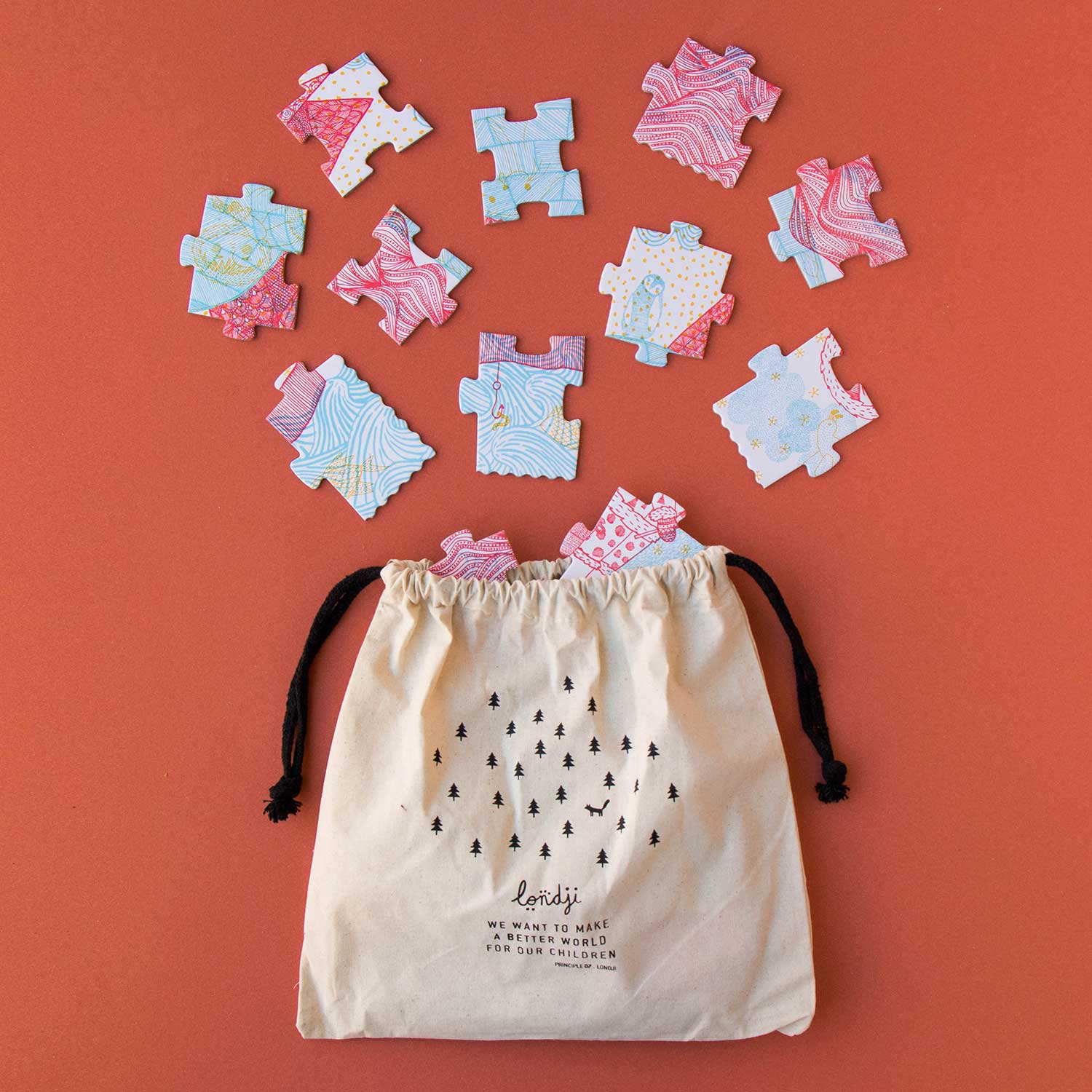 Image shows scattered puzzle pieces and a canvas draw strong bag against a red backdrop.