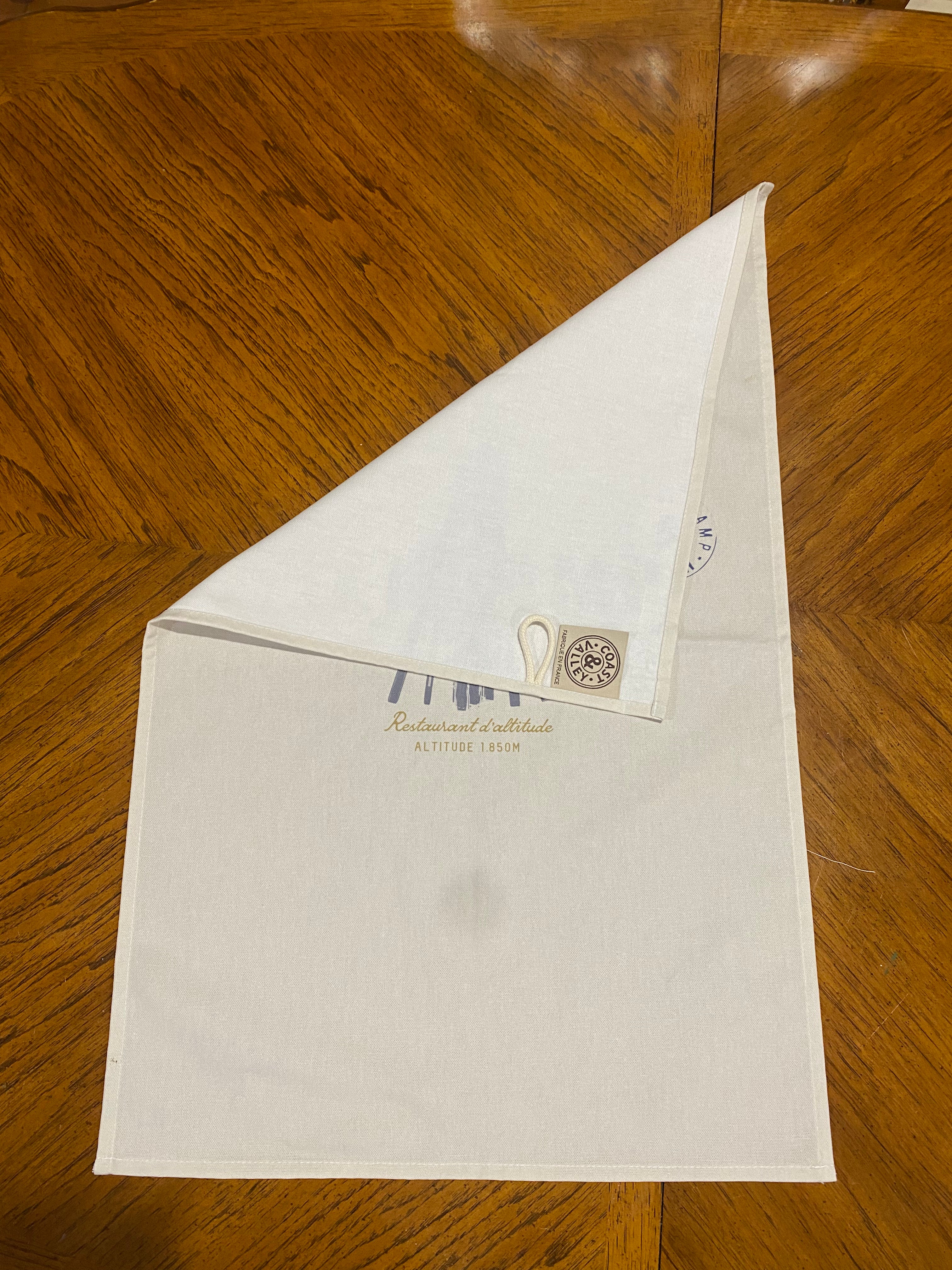 Ski Camp Tea Towel, wood background with label showing