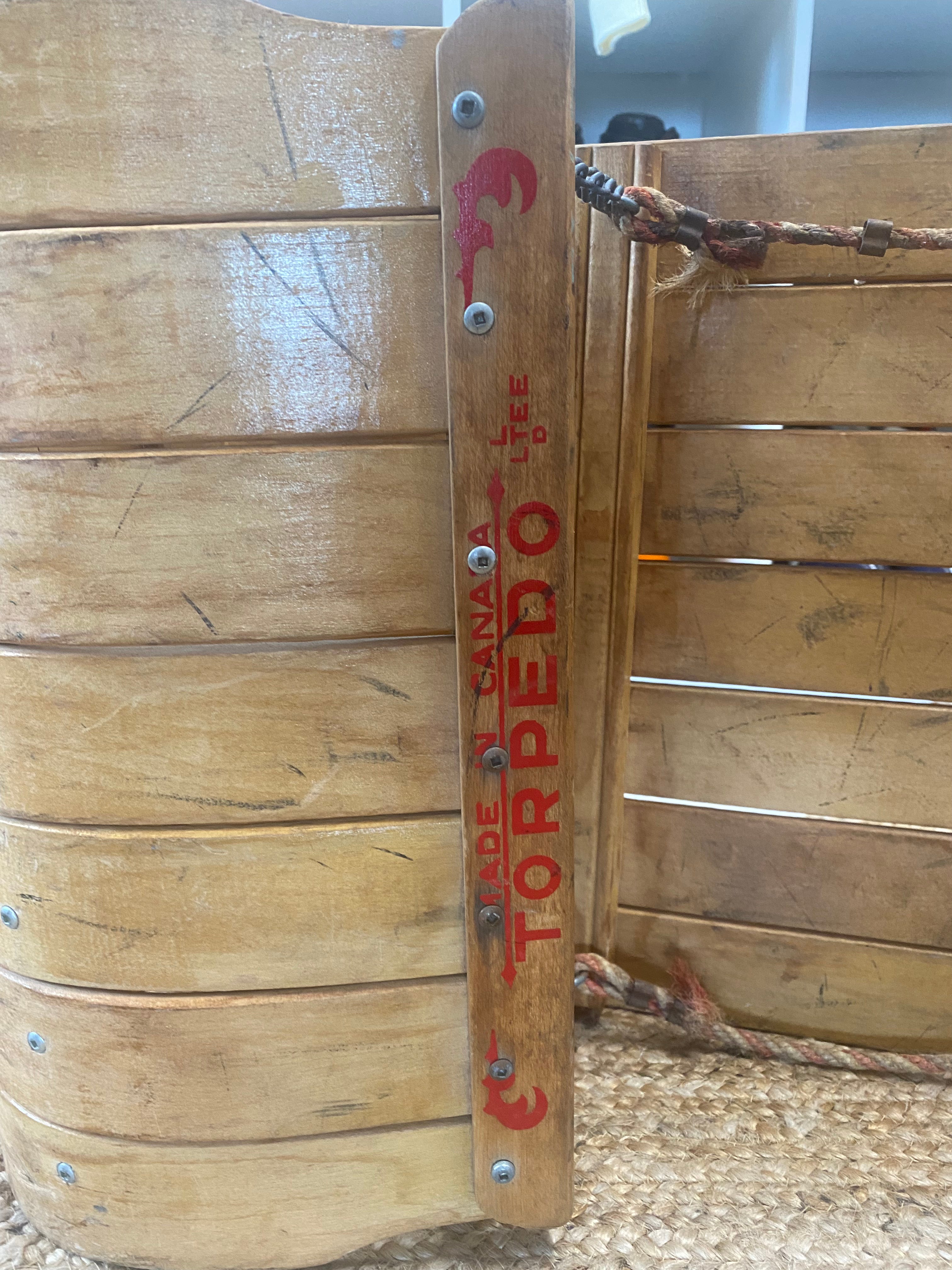 Vintage Torpedo steam bent wooden snow sled/toboggan with curved nose: close up of red writing on the curved nose 