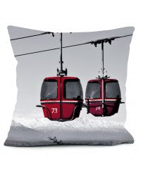 Cushion with vintage photo of red egg gondolas against a white mountain sky against a pure white backdrop