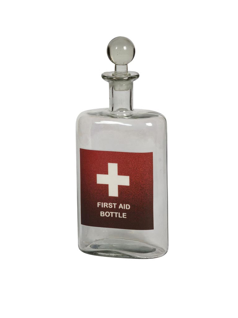Glass Decanter with the red and white First Aid symbol labels on its front & with glass stopper, on a white background
