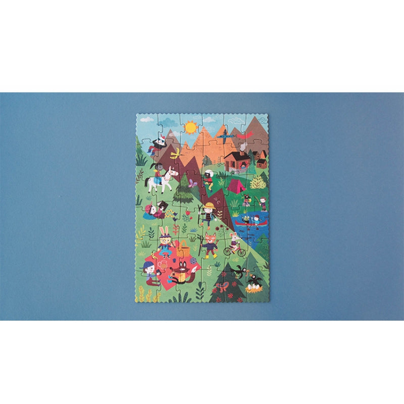 Image shows the completed puzzle with images of people and animals enjoying summer mountain  activities, against a blue background with a white border