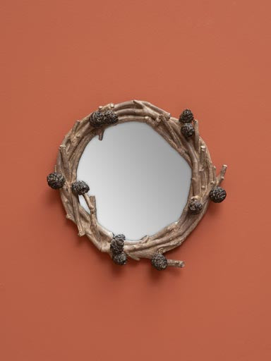 Pinecone mirror: Mirror framed by resin branches and pinecones, on a orange painted wall