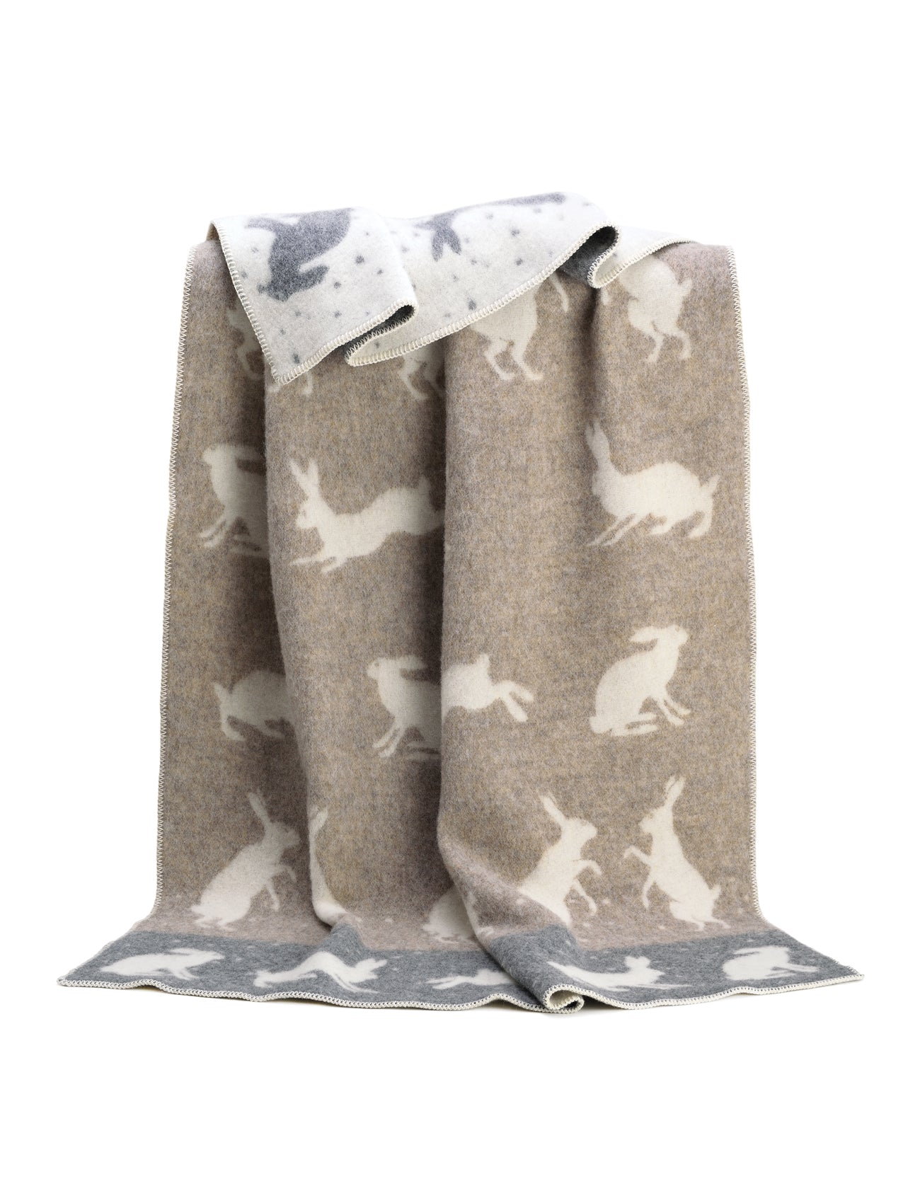 Boxing hares, sparring against a snowy background. The wintery scene on this pure wool stitched blanket will make you want to snuggle up under its soft grey and soft brown design and dream of Christmas and long walks in the countryside. 